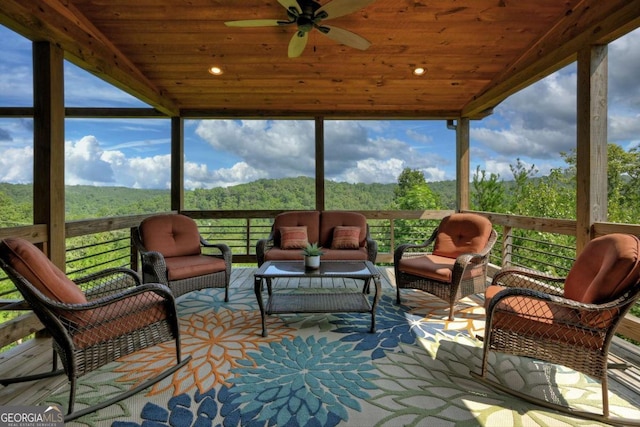 sunroom / solarium featuring plenty of natural light, wooden ceiling, and ceiling fan