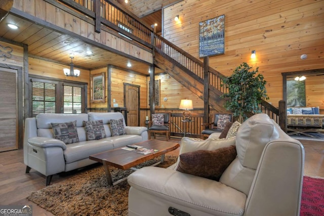 living room with hardwood / wood-style flooring, a towering ceiling, wooden ceiling, and wooden walls