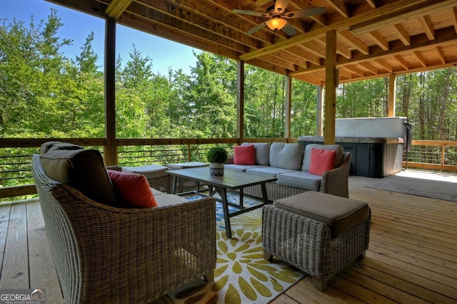 deck with ceiling fan, an outdoor living space, and a covered hot tub