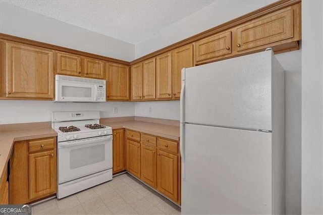 kitchen with a textured ceiling and white appliances