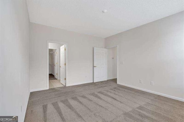 unfurnished room featuring light carpet and a textured ceiling