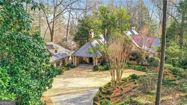 view of property hidden behind natural elements featuring a carport