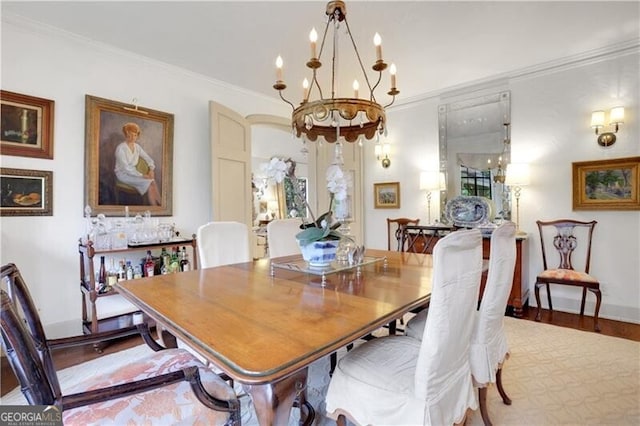 dining room featuring ornamental molding, wood-type flooring, and a notable chandelier