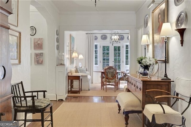 sitting room featuring crown molding, light hardwood / wood-style floors, and french doors