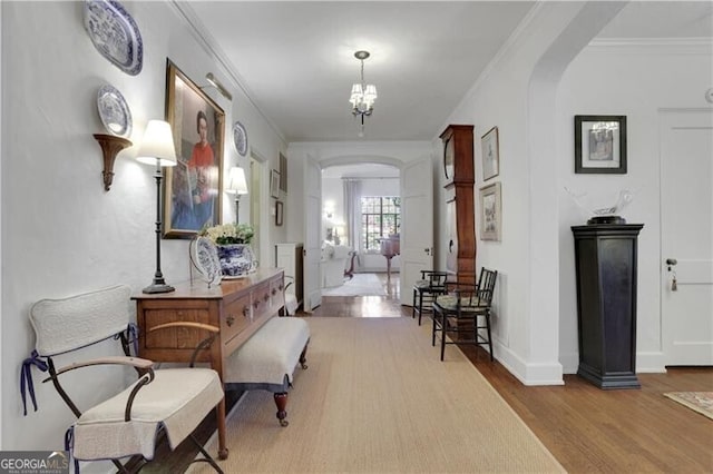 interior space featuring crown molding, an inviting chandelier, and light wood-type flooring