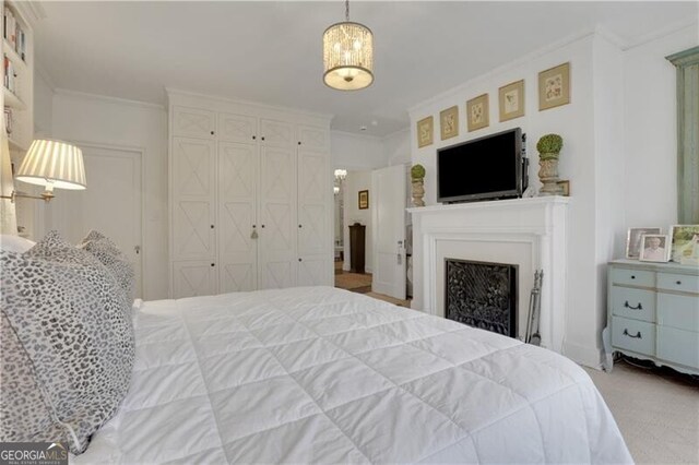 bedroom featuring light carpet, ornamental molding, and a closet