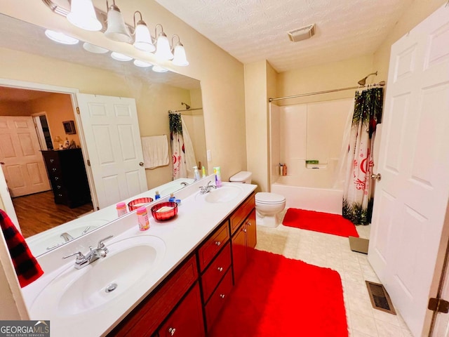 full bathroom with toilet, vanity, a textured ceiling, and shower / bath combo with shower curtain