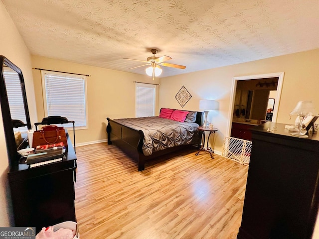 bedroom featuring ceiling fan, a textured ceiling, and light hardwood / wood-style floors