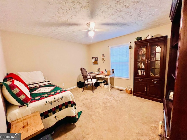 bedroom with light carpet, ceiling fan, and a textured ceiling