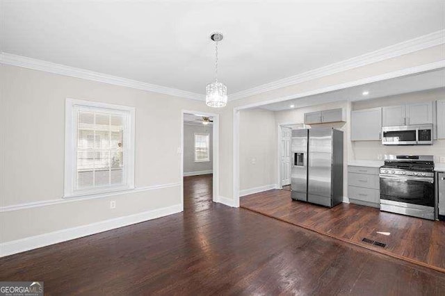 kitchen with ornamental molding, dark wood-type flooring, gray cabinets, and stainless steel appliances