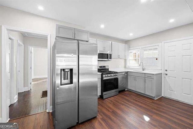 kitchen featuring dark hardwood / wood-style flooring, sink, gray cabinets, and appliances with stainless steel finishes