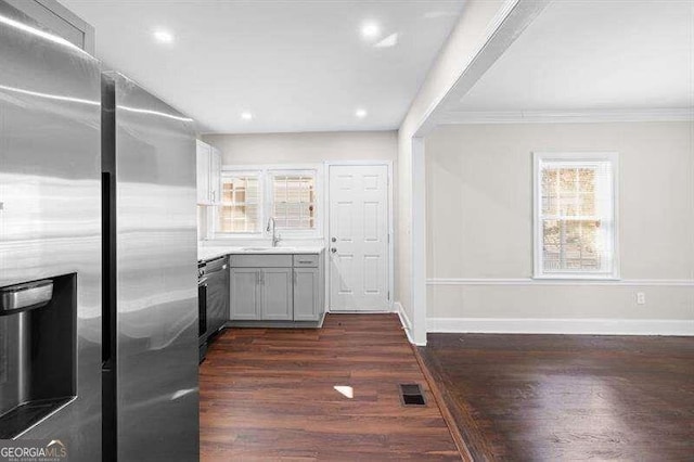 kitchen with sink, stainless steel fridge with ice dispenser, ornamental molding, dark hardwood / wood-style flooring, and gray cabinets