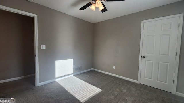 carpeted spare room with ceiling fan