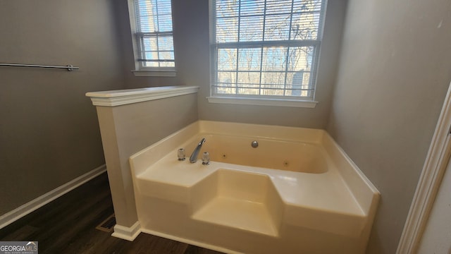 bathroom featuring a tub to relax in and wood-type flooring