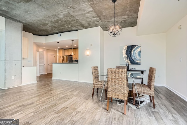 dining space featuring an inviting chandelier and light hardwood / wood-style floors