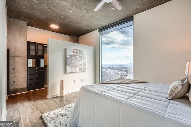 bedroom with a wall of windows and wood-type flooring