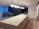 kitchen featuring hardwood / wood-style flooring, a kitchen island, and decorative light fixtures