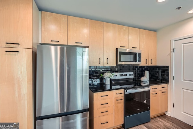 kitchen featuring tasteful backsplash, appliances with stainless steel finishes, hardwood / wood-style flooring, and light brown cabinets