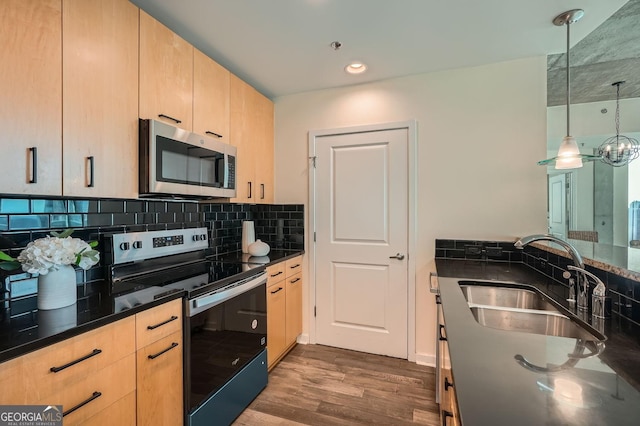 kitchen featuring light brown cabinetry, sink, hanging light fixtures, stainless steel appliances, and backsplash