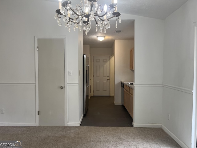 corridor featuring dark colored carpet and a textured ceiling