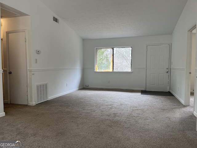 unfurnished room with carpet floors and a textured ceiling