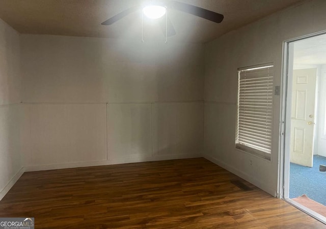 unfurnished room featuring ceiling fan and dark hardwood / wood-style flooring