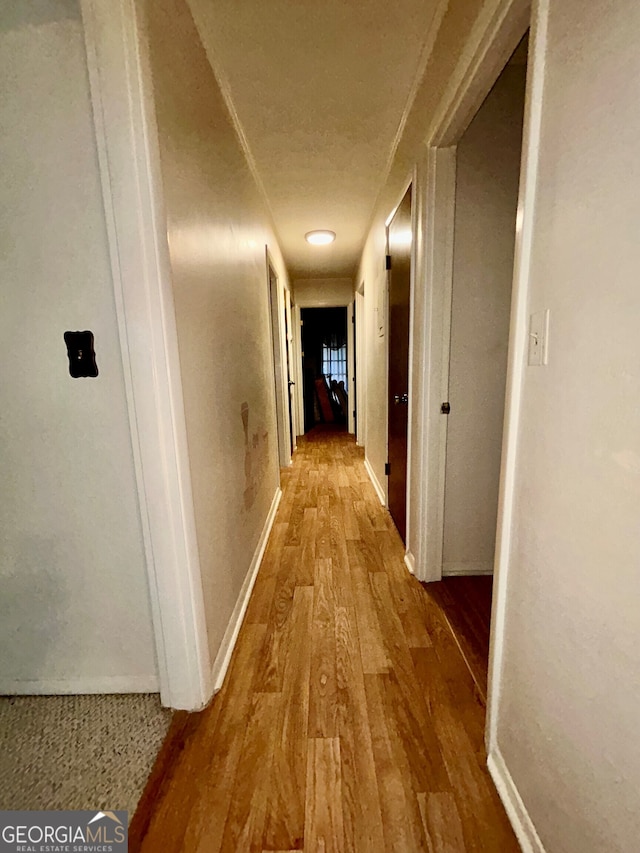 hallway with hardwood / wood-style floors