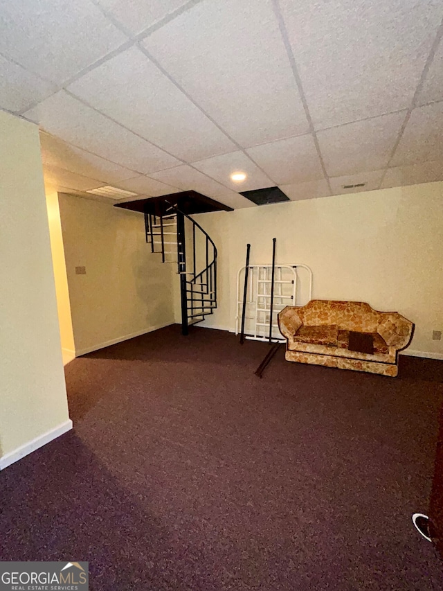 basement with carpet and a paneled ceiling