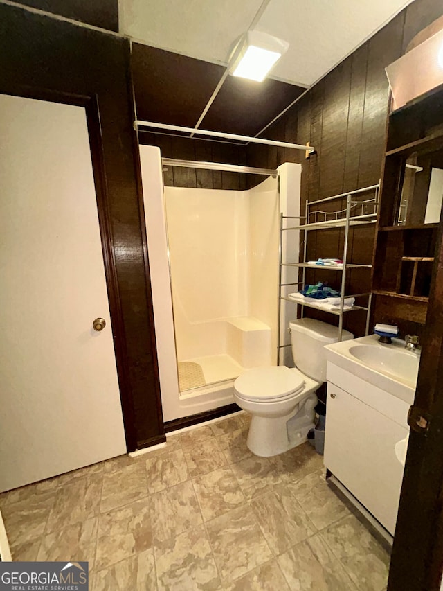 bathroom with walk in shower, vanity, and toilet