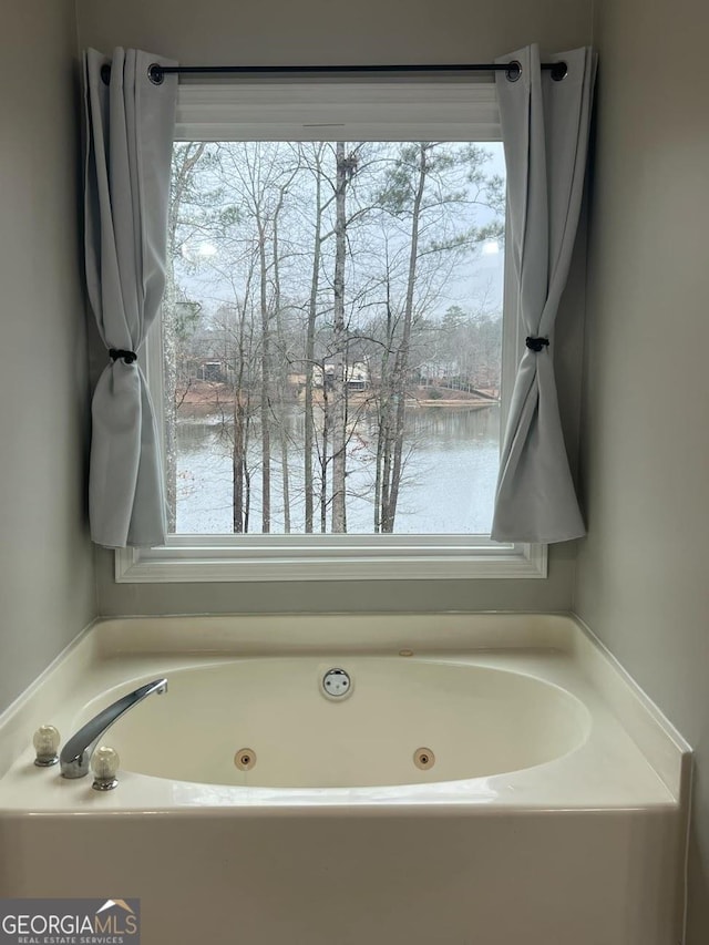 bathroom featuring a water view and a tub to relax in