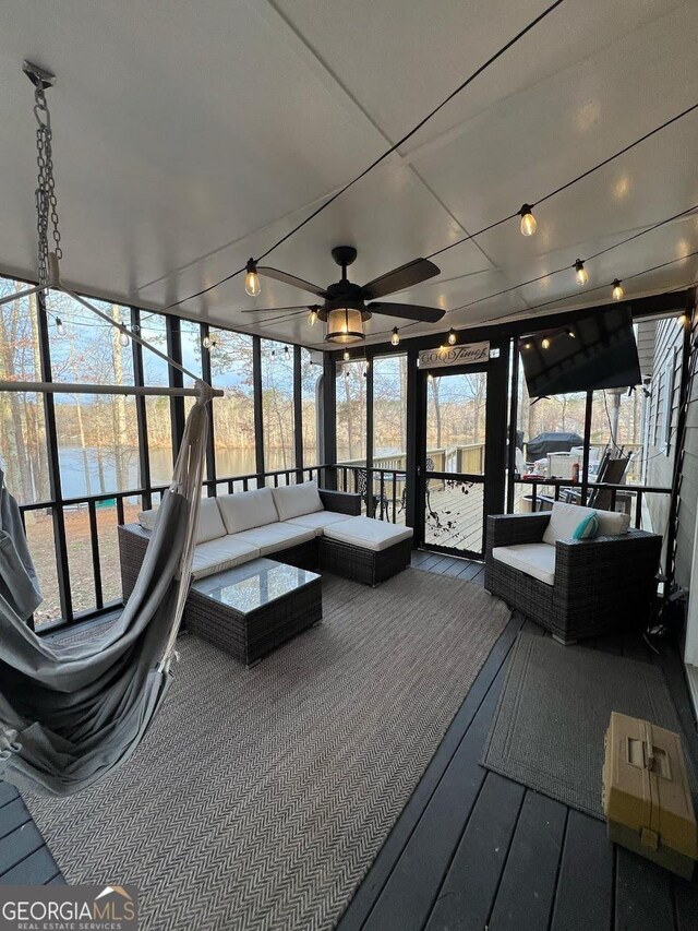 unfurnished sunroom with a water view and ceiling fan