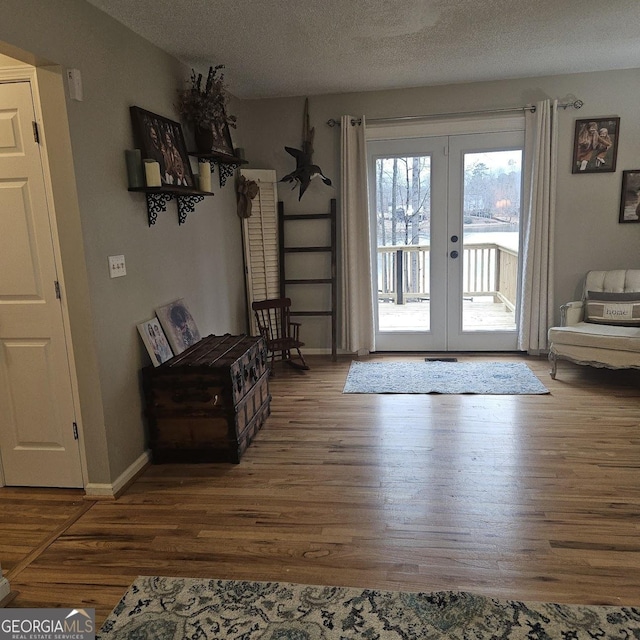 entryway with dark wood-type flooring, a textured ceiling, and french doors