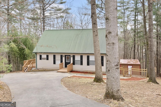 view of front facade featuring driveway and metal roof