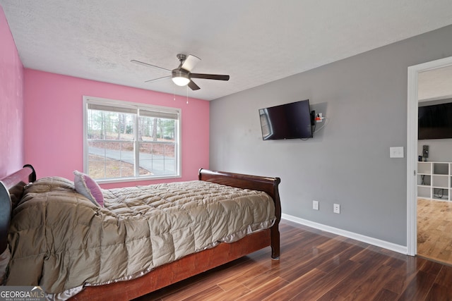 bedroom with wood finished floors, baseboards, a ceiling fan, and a textured ceiling