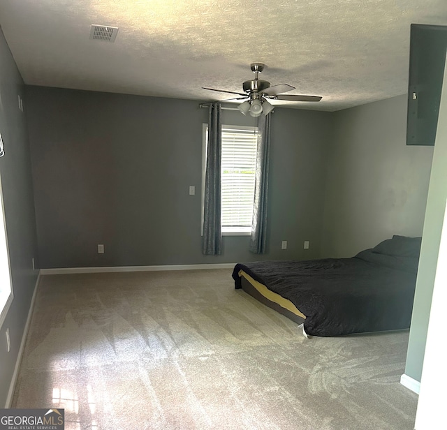 unfurnished bedroom featuring carpet, baseboards, electric panel, a textured ceiling, and ceiling fan