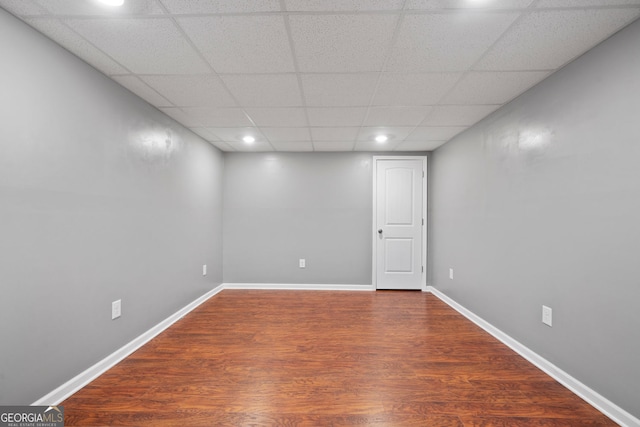 empty room with wood finished floors, recessed lighting, baseboards, and a drop ceiling