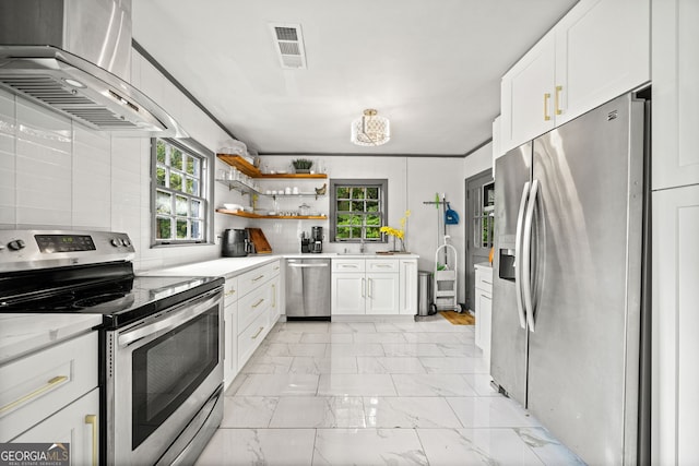 kitchen featuring stainless steel appliances, a healthy amount of sunlight, island range hood, and white cabinets