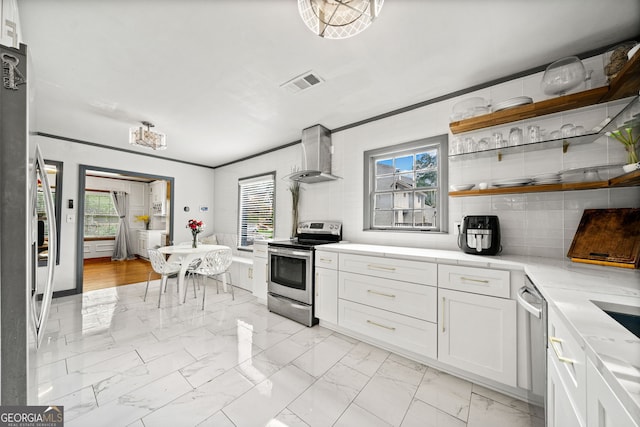 kitchen featuring a healthy amount of sunlight, white cabinets, stainless steel appliances, and wall chimney exhaust hood