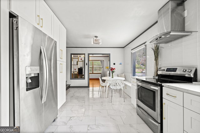 kitchen featuring extractor fan, white cabinets, light stone counters, stainless steel appliances, and crown molding