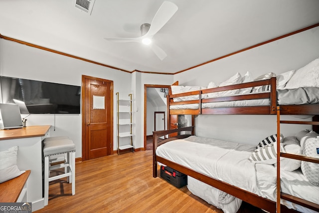 bedroom featuring light hardwood / wood-style flooring, ornamental molding, and ceiling fan