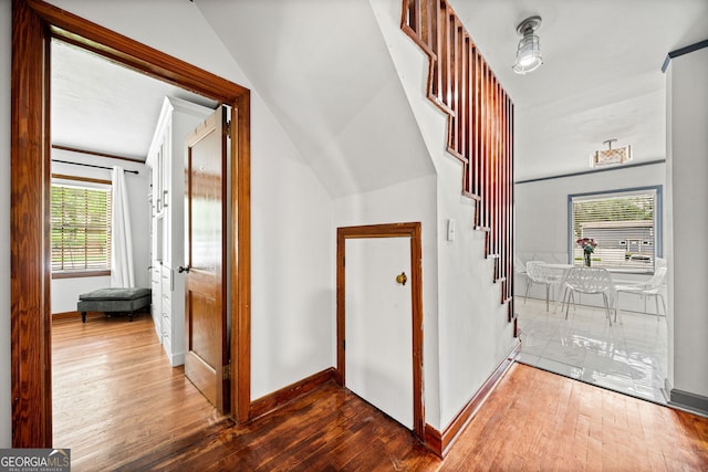 hall featuring lofted ceiling and hardwood / wood-style floors