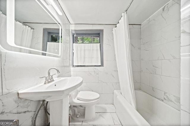 bathroom featuring tile walls, shower / tub combo, and toilet