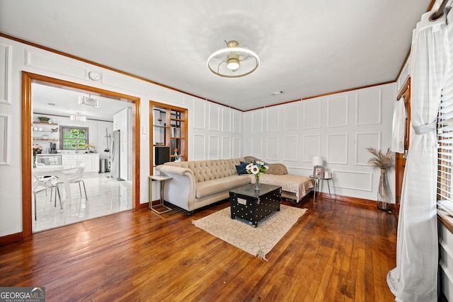 living room with dark hardwood / wood-style flooring and ornamental molding