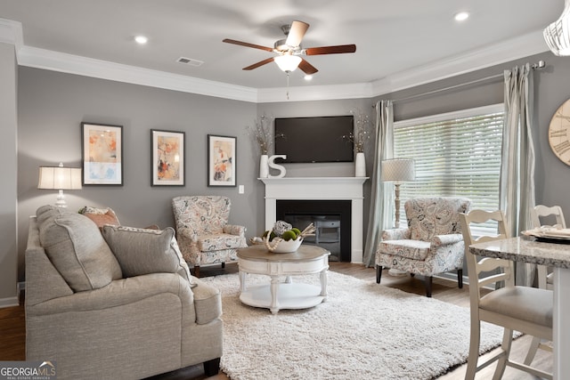 living room with crown molding, ceiling fan, and hardwood / wood-style flooring