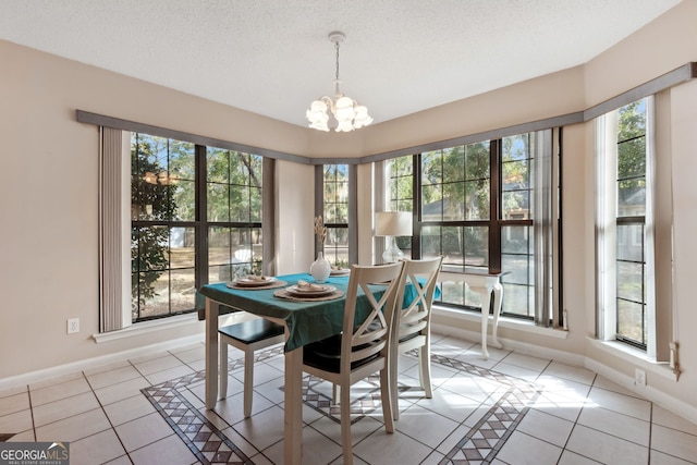 tiled dining space featuring an inviting chandelier and a textured ceiling