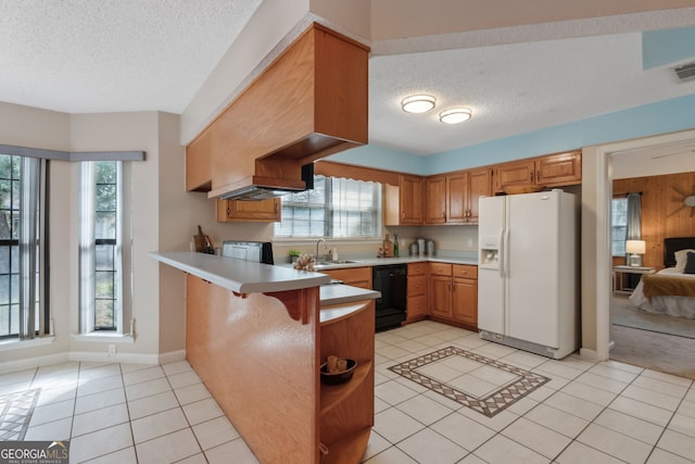 kitchen with a breakfast bar, black dishwasher, white fridge with ice dispenser, light tile patterned flooring, and kitchen peninsula