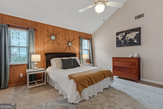 bedroom featuring vaulted ceiling, light colored carpet, and wood walls