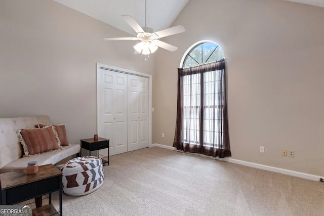 living area with ceiling fan, carpet flooring, and high vaulted ceiling