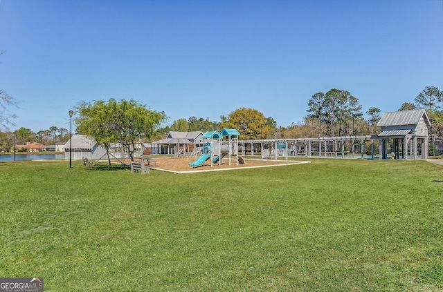 view of jungle gym featuring a water view and a lawn