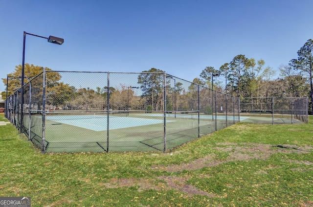 view of tennis court with a lawn